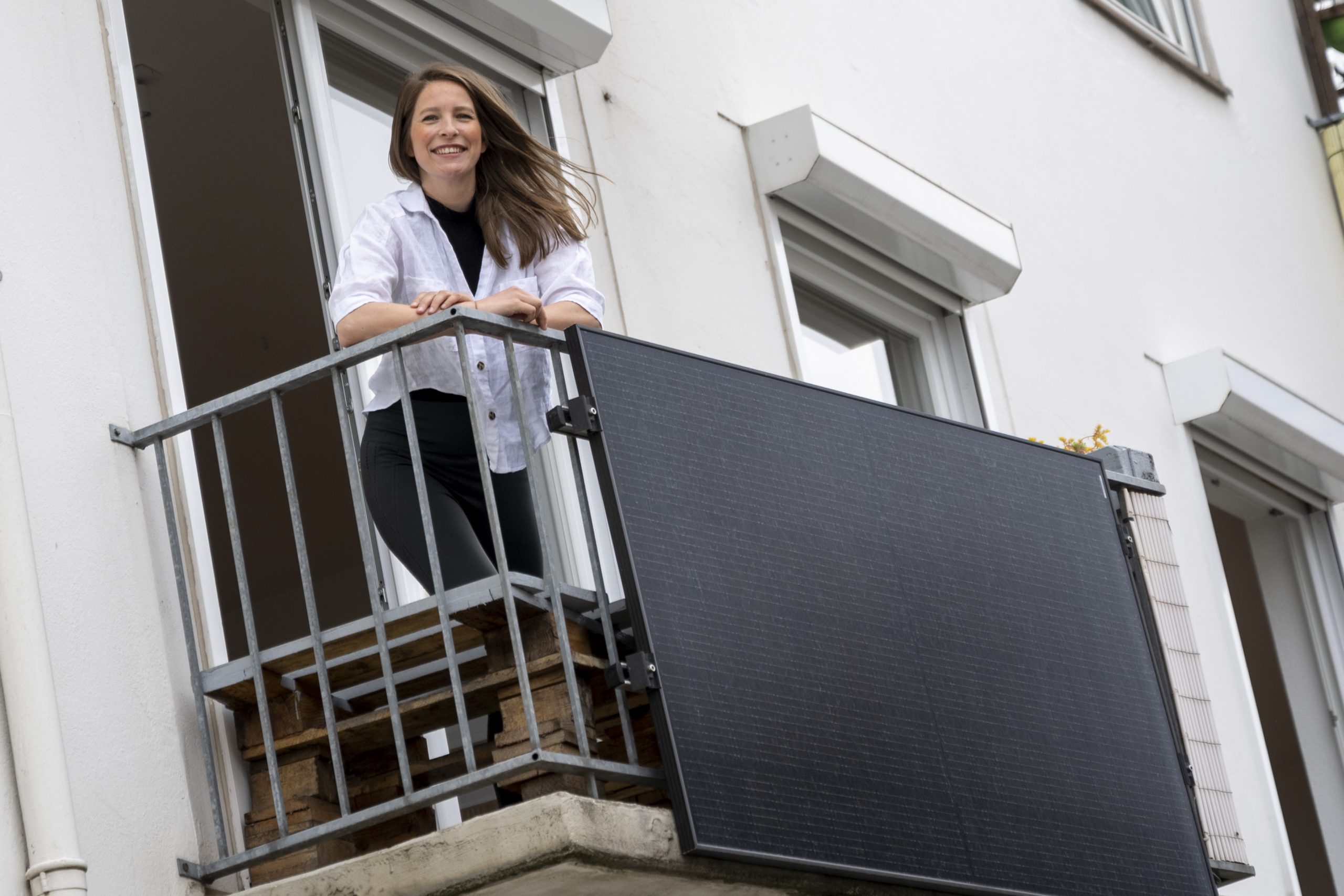 Foto: Mensch auf einem Balkon mit installiertem Solarmodul vom Bremer SolidarStrom
